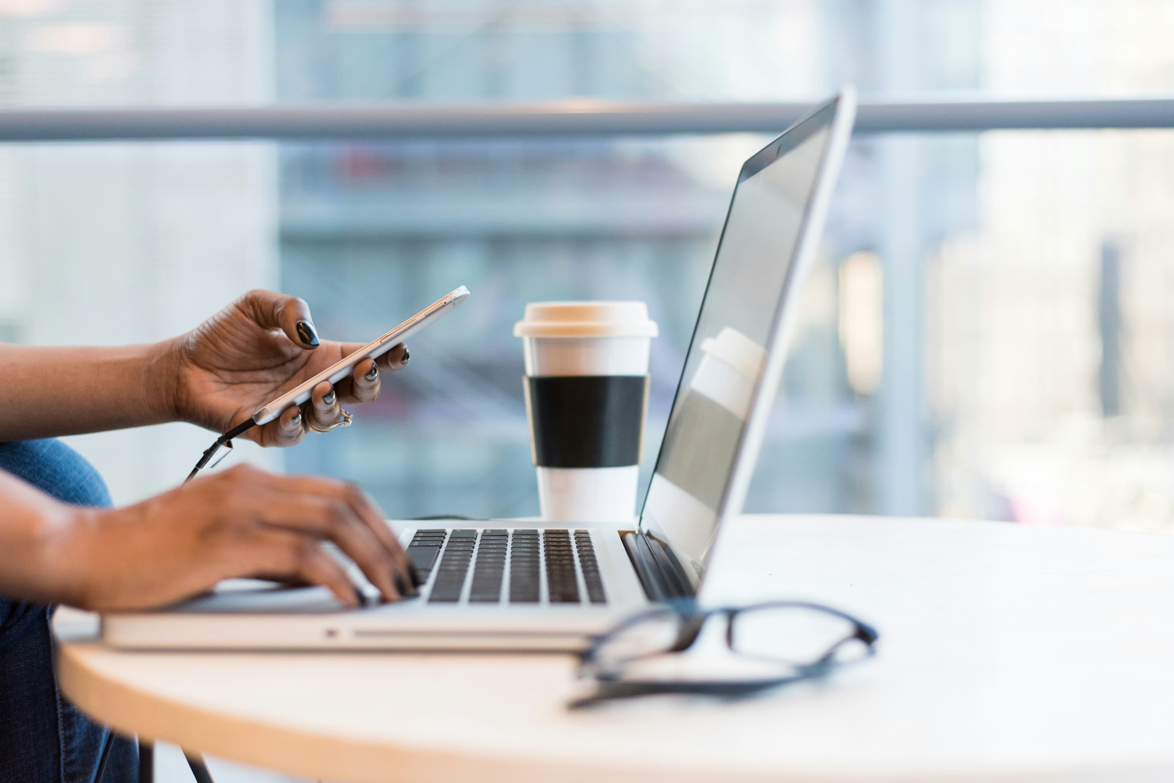 a pc with a cofee on the table